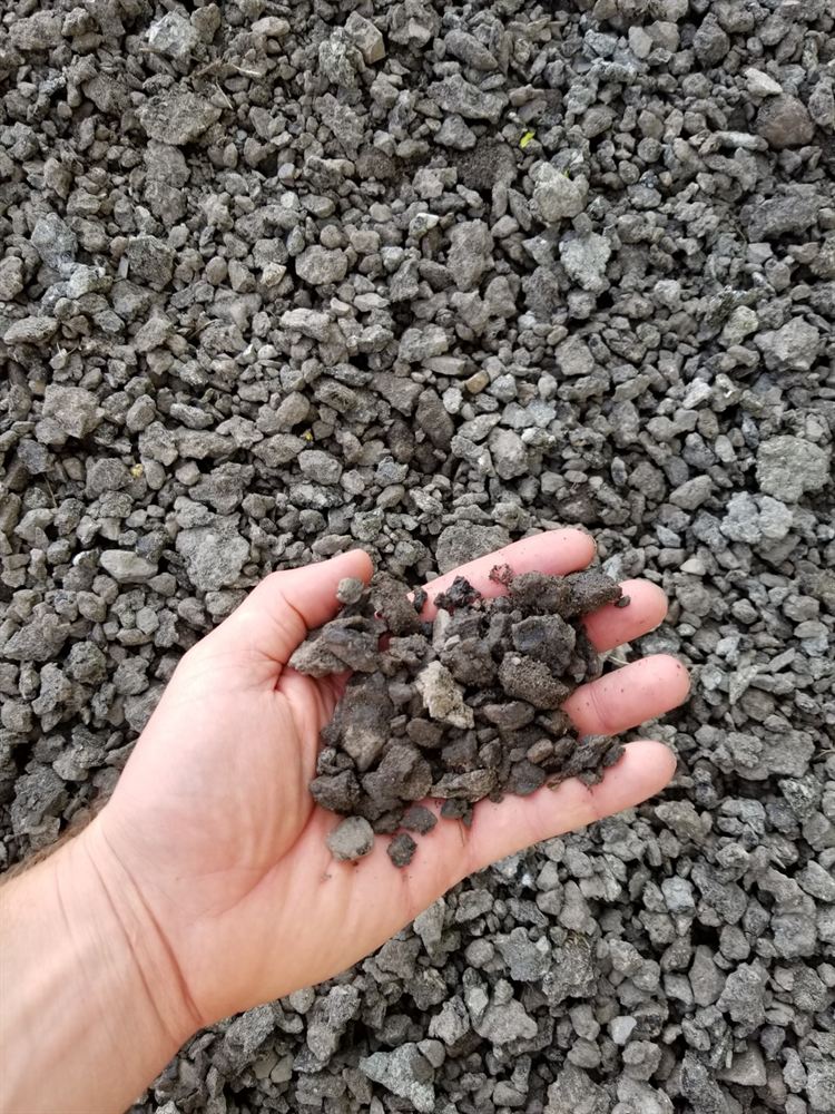 Close-up of recycled asphalt millings held in a hand
